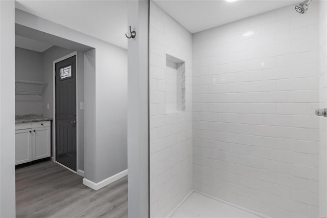 bathroom with hardwood / wood-style flooring, vanity, and walk in shower