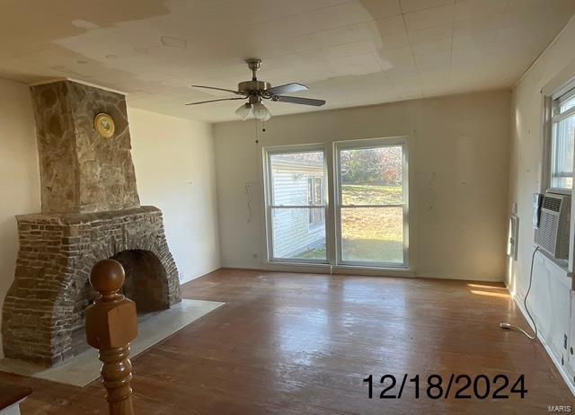 unfurnished living room featuring ceiling fan and hardwood / wood-style flooring