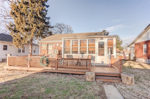 back of property featuring a sunroom and a deck