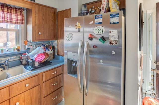 kitchen with decorative backsplash, sink, and stainless steel refrigerator with ice dispenser