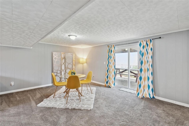 dining space featuring carpet and wooden walls