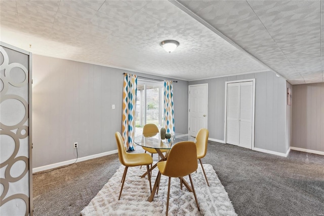 carpeted dining room with wood walls