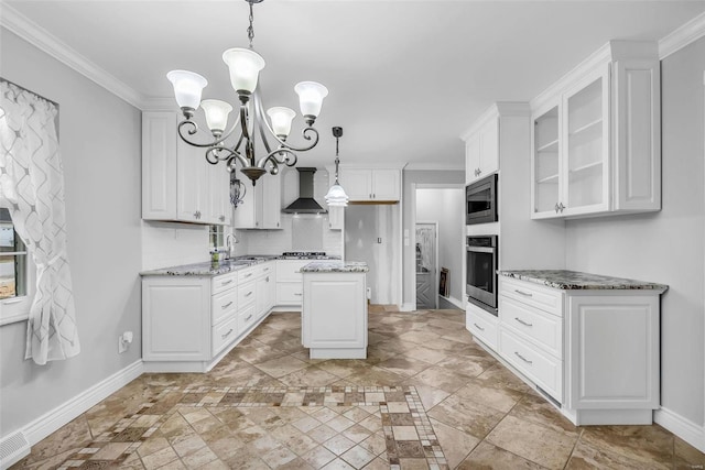 kitchen featuring white cabinets, a center island, light stone countertops, and wall chimney exhaust hood