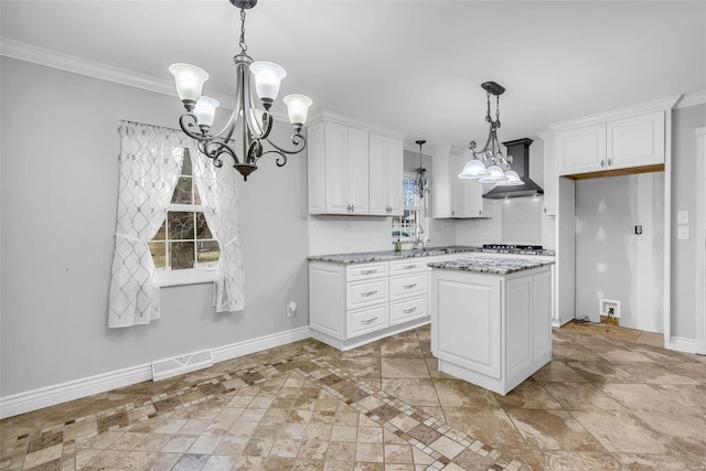 kitchen with decorative backsplash, white cabinets, light stone countertops, and a kitchen island