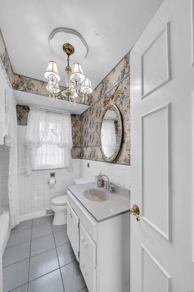 bathroom with tile patterned flooring, vanity, an inviting chandelier, and toilet