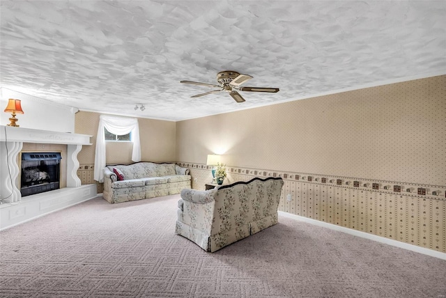 carpeted living room with a textured ceiling, ceiling fan, and crown molding