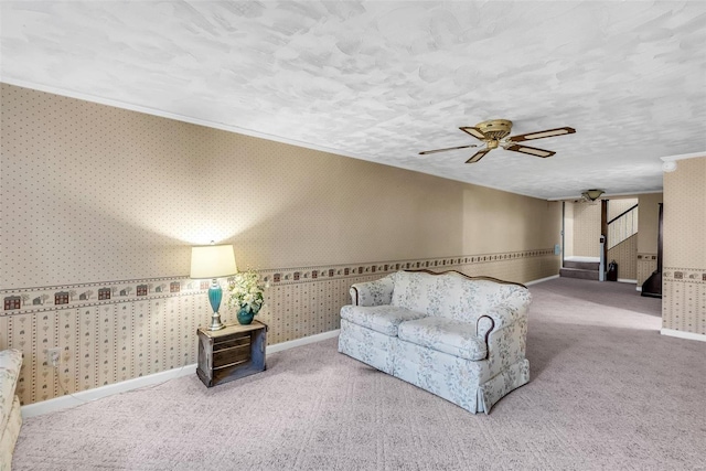 living room featuring carpet flooring, ceiling fan, and a textured ceiling