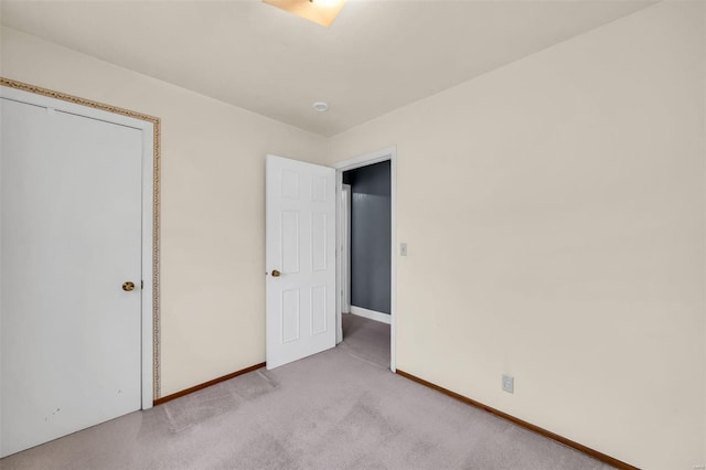 unfurnished bedroom featuring light colored carpet and a closet