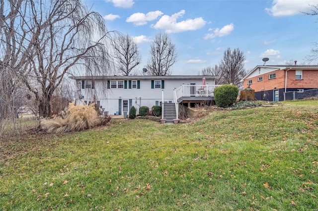 back of house featuring a lawn and a deck