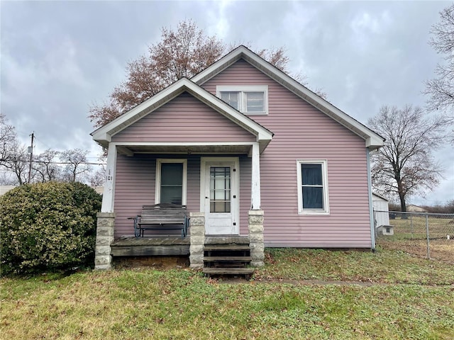 bungalow-style home with covered porch and a front lawn