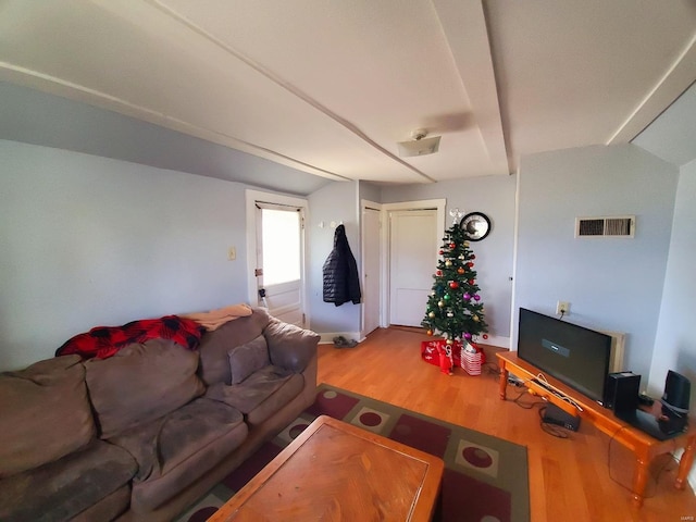 living room with hardwood / wood-style flooring and vaulted ceiling