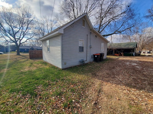 view of property exterior with a yard and a carport