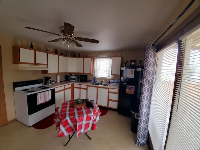 kitchen featuring ceiling fan, electric stove, white cabinets, and black fridge