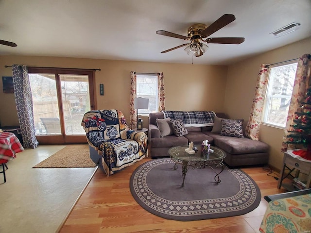 living room featuring ceiling fan, plenty of natural light, and light hardwood / wood-style floors