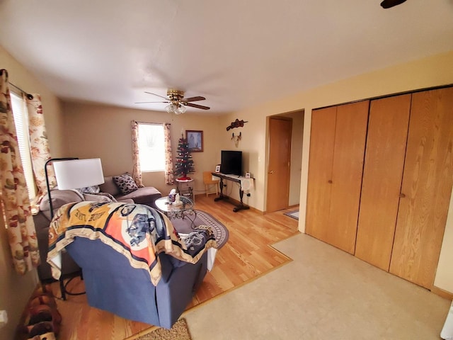 living room featuring ceiling fan and light hardwood / wood-style floors