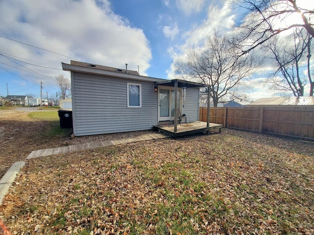 back of house featuring fence and a deck