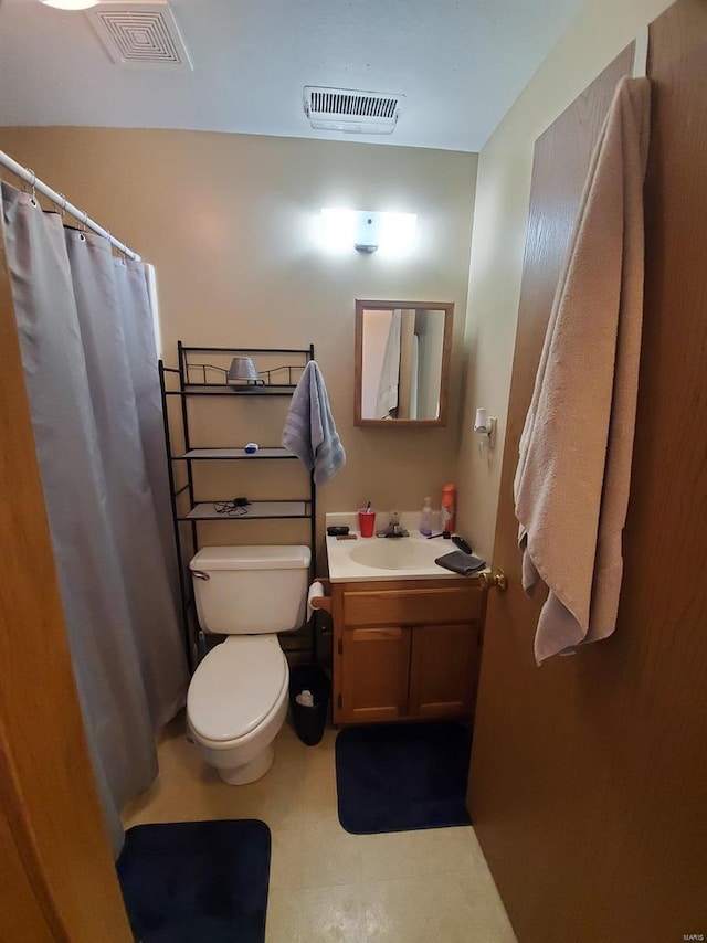 bathroom featuring toilet, a shower with curtain, visible vents, and vanity