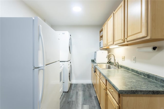 kitchen with light brown cabinetry, dark hardwood / wood-style flooring, white appliances, sink, and stacked washer / drying machine