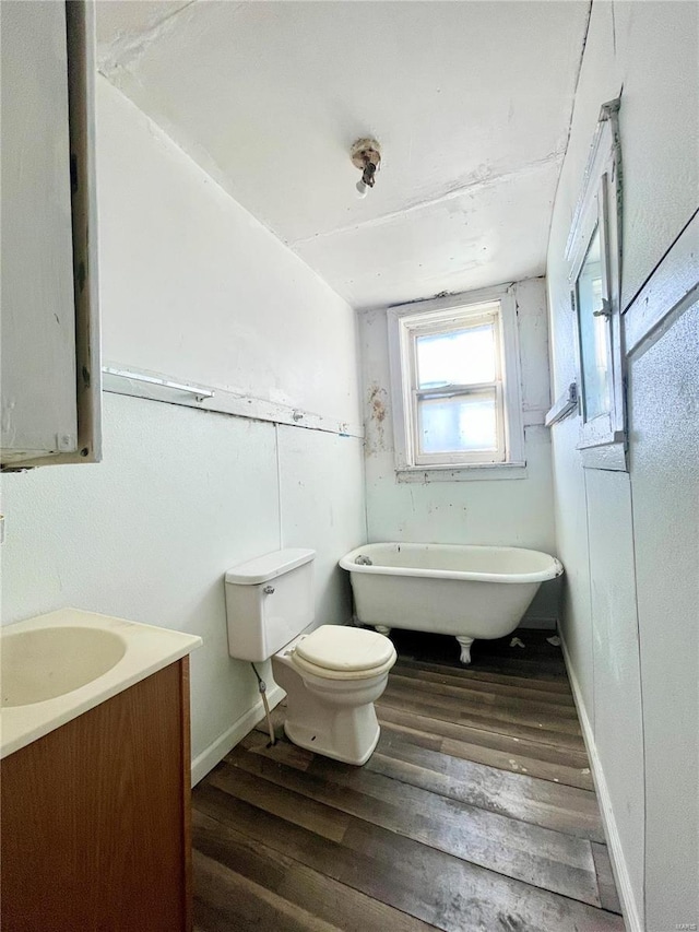 bathroom featuring vanity, hardwood / wood-style flooring, toilet, and a bathtub