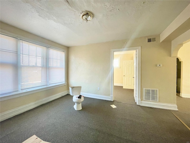 carpeted spare room featuring a textured ceiling