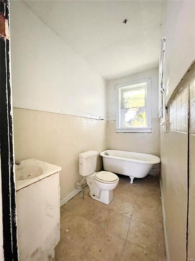 bathroom featuring vanity, toilet, and a bath