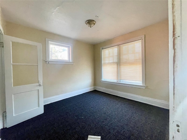 empty room with dark colored carpet