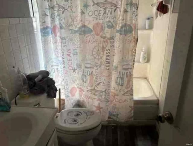 full bathroom featuring shower / bath combo, vanity, toilet, and tile walls