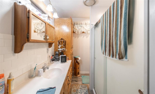 bathroom featuring tasteful backsplash, vanity, and a shower with shower door