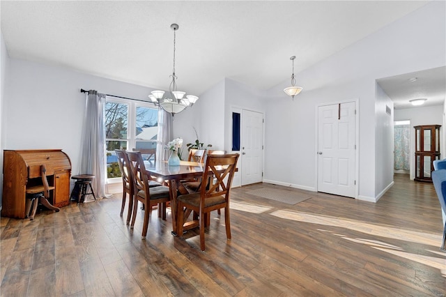 dining space featuring a chandelier, lofted ceiling, and dark hardwood / wood-style flooring