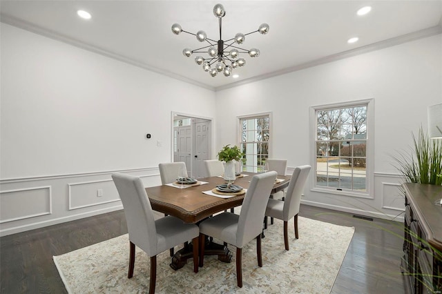 dining room featuring dark hardwood / wood-style floors, ornamental molding, and an inviting chandelier