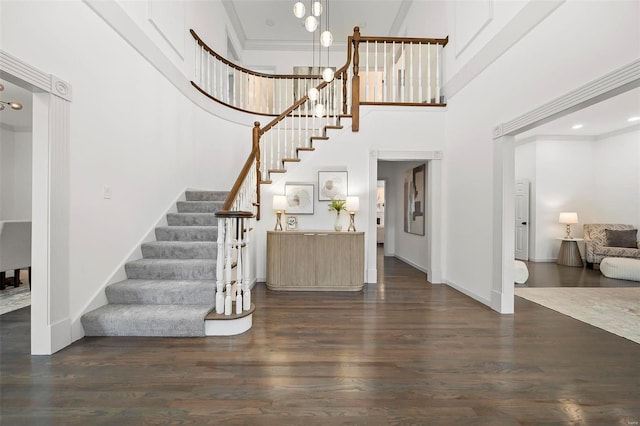 foyer entrance featuring crown molding, a high ceiling, and dark wood-type flooring