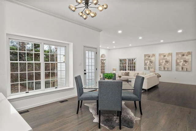 dining space with crown molding, dark wood-type flooring, and a chandelier