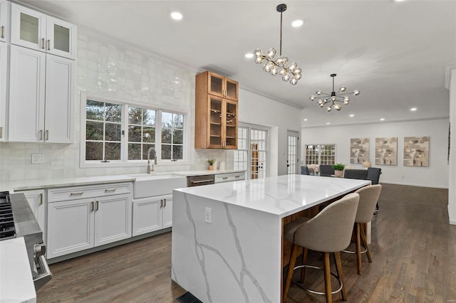 kitchen featuring decorative backsplash, a center island, white cabinets, and sink