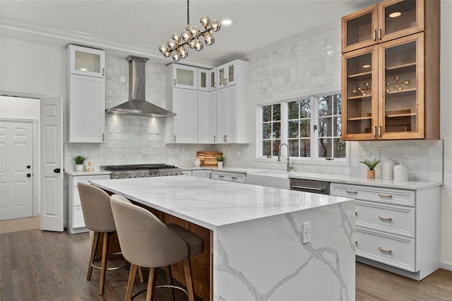 kitchen with wall chimney exhaust hood, a center island, and white cabinetry