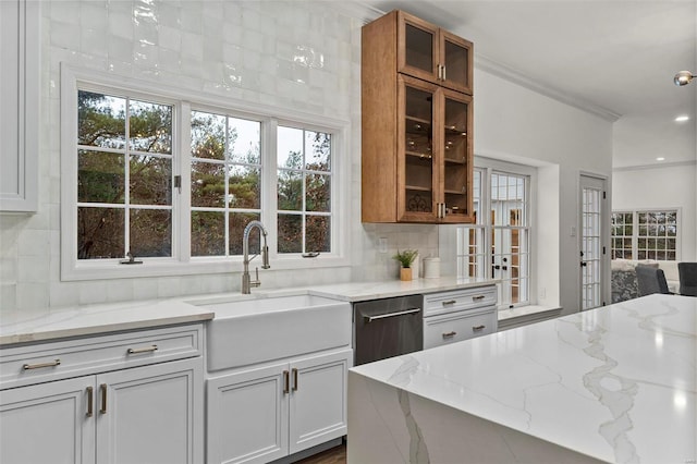 kitchen with white cabinets, light stone countertops, sink, and tasteful backsplash