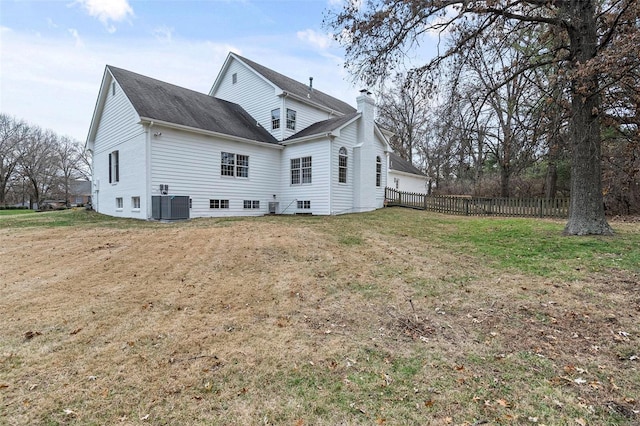 rear view of house with a yard and central air condition unit