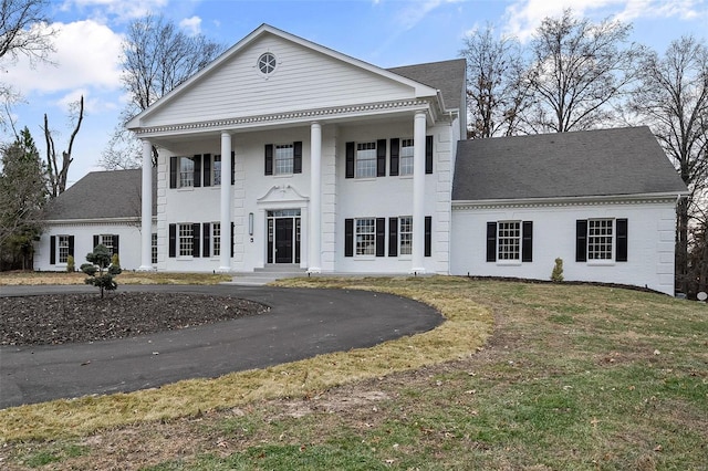 greek revival inspired property featuring a front lawn