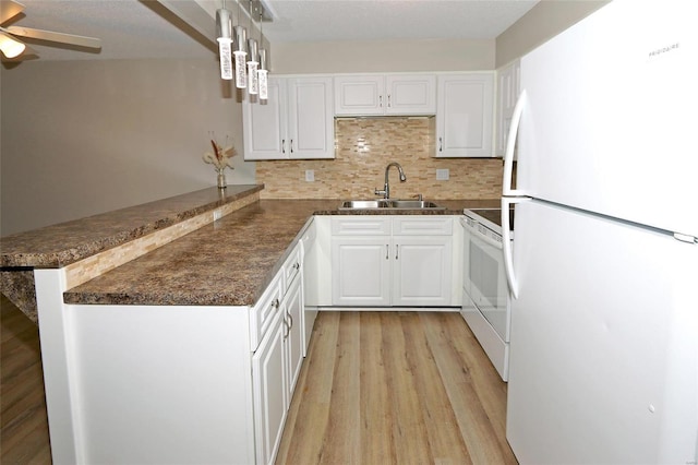 kitchen with sink, kitchen peninsula, pendant lighting, white appliances, and white cabinets