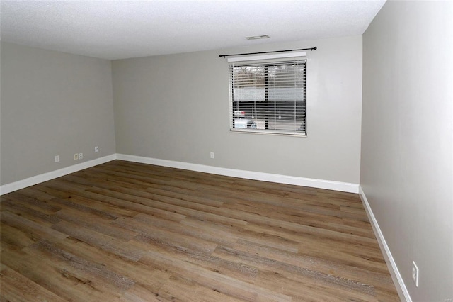 spare room with hardwood / wood-style floors and a textured ceiling