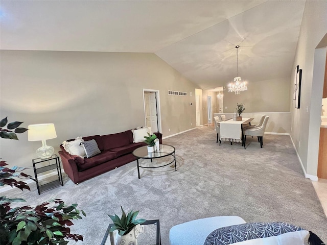 carpeted living room featuring a chandelier and vaulted ceiling