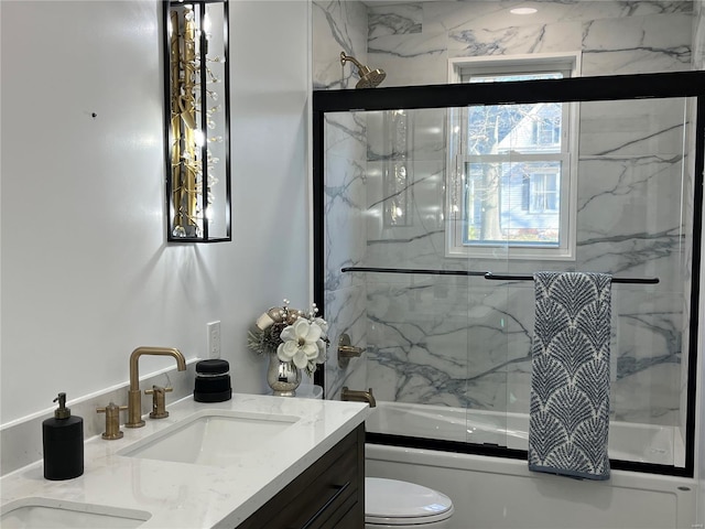 full bathroom featuring shower / bath combination with glass door, vanity, and toilet