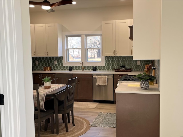 kitchen with dishwasher, light hardwood / wood-style floors, white cabinetry, and sink