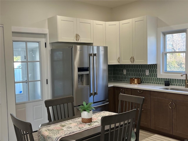 kitchen with dark brown cabinetry, white cabinetry, sink, and high quality fridge