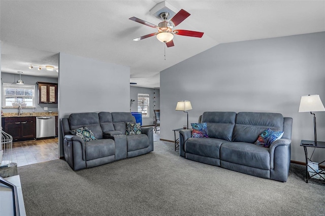 carpeted living room featuring lofted ceiling, sink, and ceiling fan