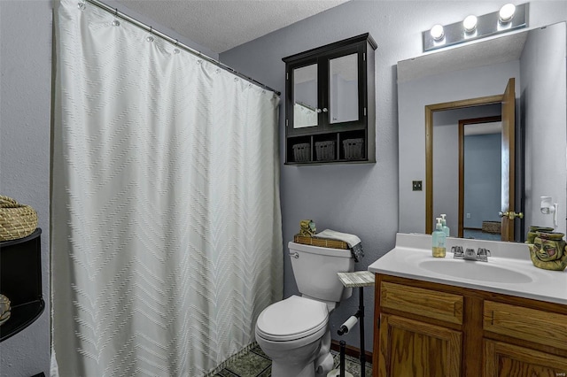 bathroom with vanity, toilet, and a textured ceiling