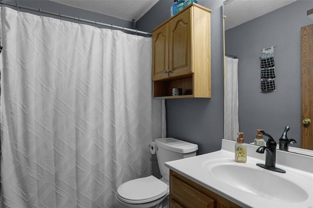 bathroom featuring vanity, a textured ceiling, and toilet