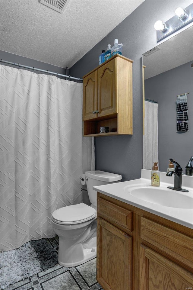 bathroom featuring vanity, toilet, and a textured ceiling