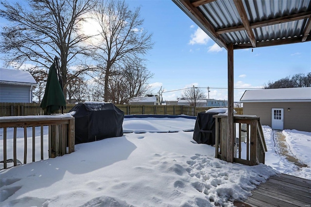 yard covered in snow with an outdoor structure and a deck