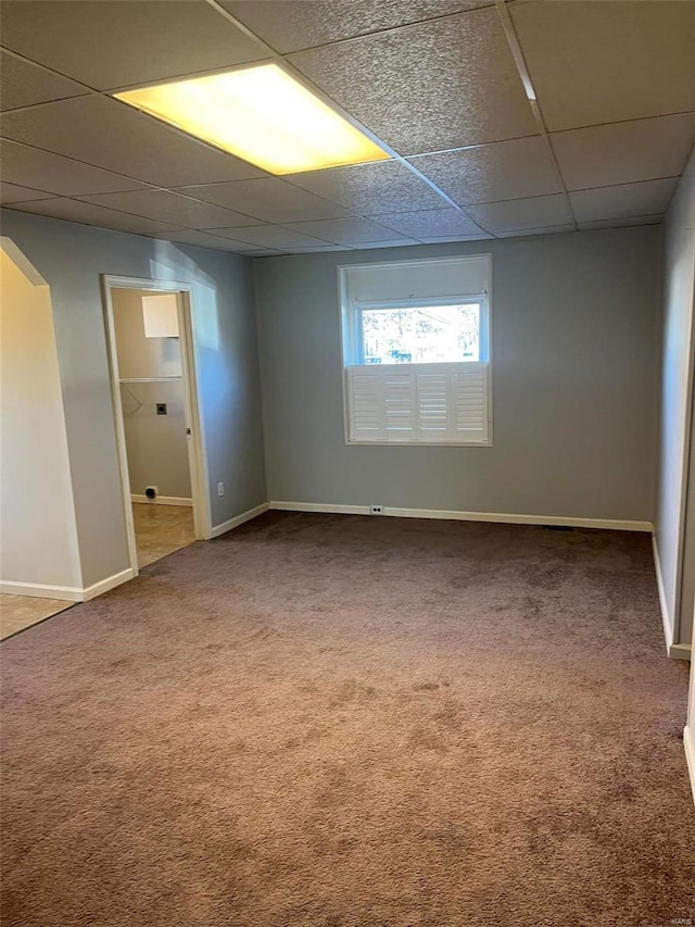 carpeted empty room with a drop ceiling