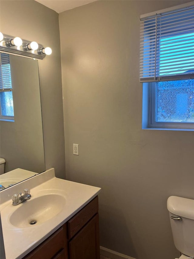 bathroom featuring vanity, toilet, and a wealth of natural light